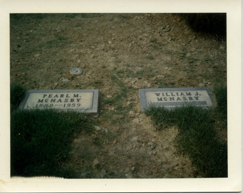 A photograph of two markers. The marker on the left reads "Pearl M. McNasby" and 1888-1959. The marker on the right reads "William J. McNasby" with no dates beneath the name. Presumably, this marker is for her husband, who at the time of the photograph had not yet passed.
